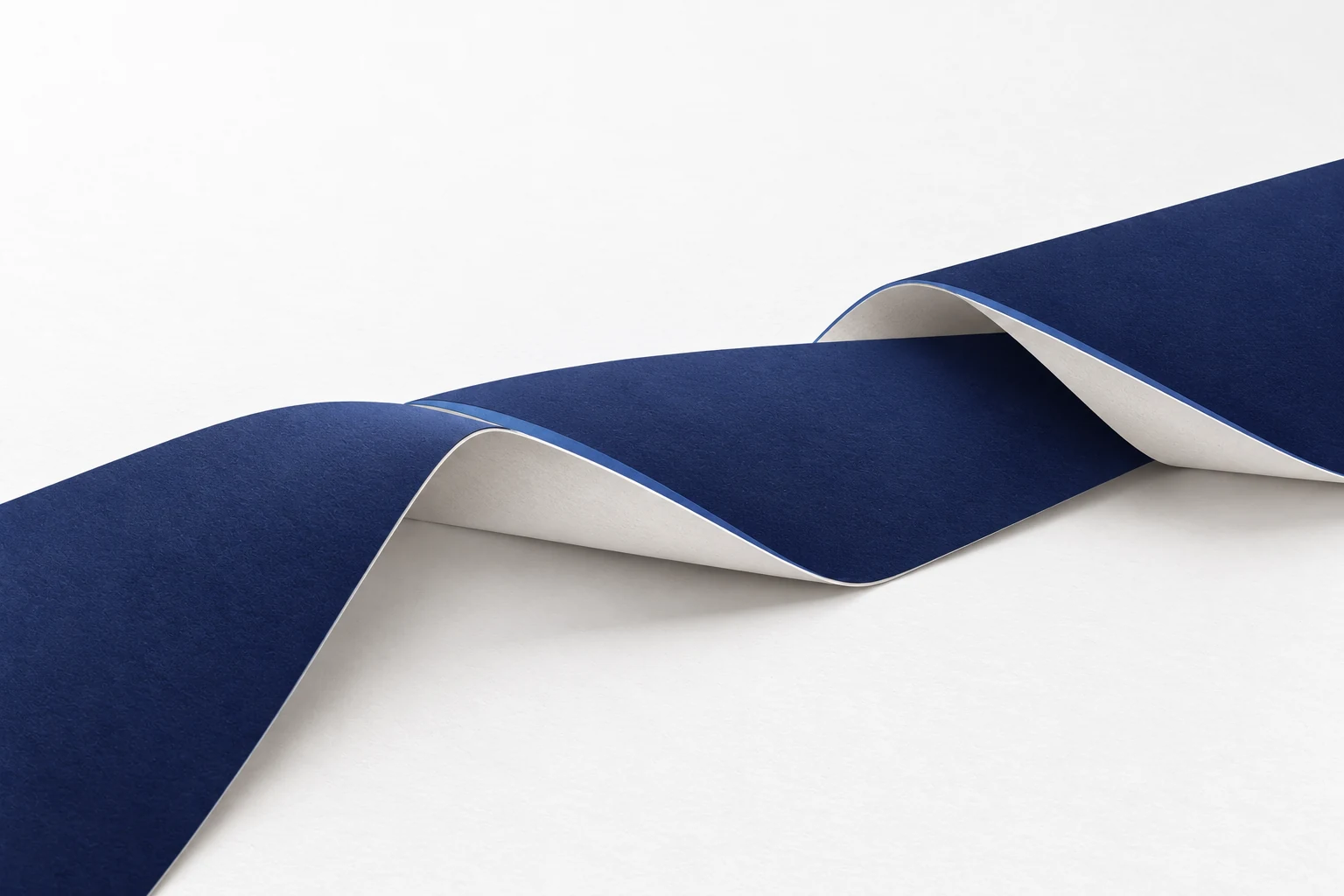 Broad folded paper sections overlap at two precise seams, creating a continuous path.